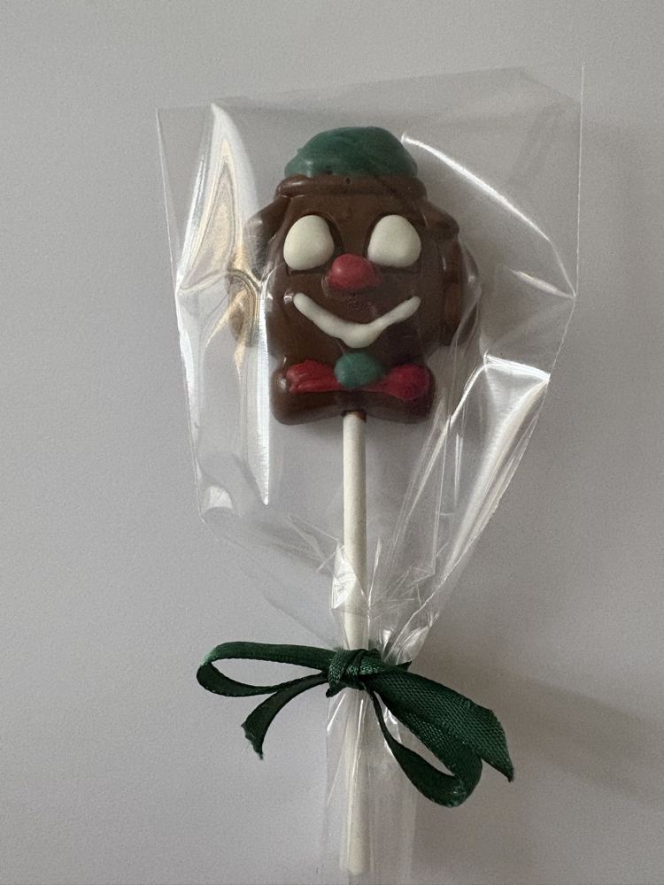 Sucette en chocolat décorée en forme de clown, emballée avec un ruban vert